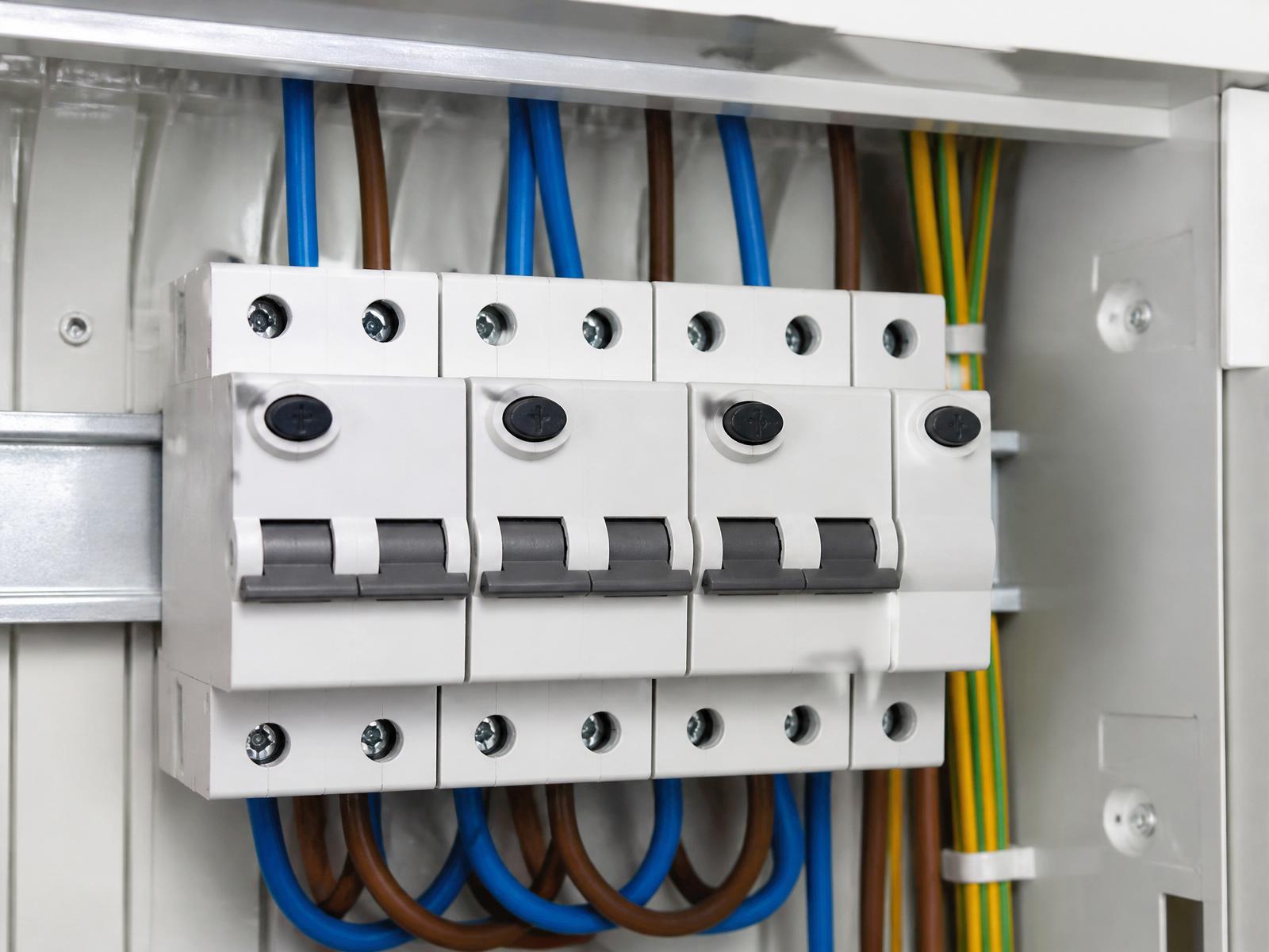 Row of white RCBO devices installed on the DIN rail of a modern switchboard.